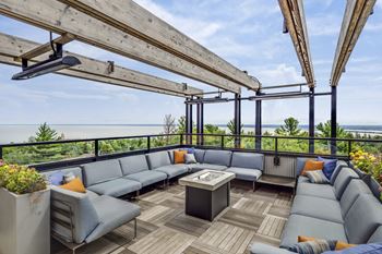 A rooftop patio with couches and a table